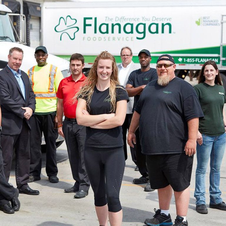team of people with flangan truck in background