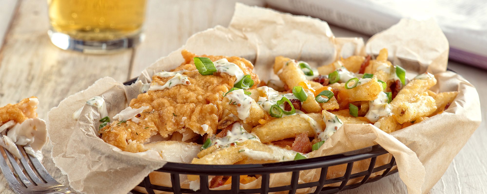 Poisson pané à la bière avec des frites au cheddar chargées de bacon